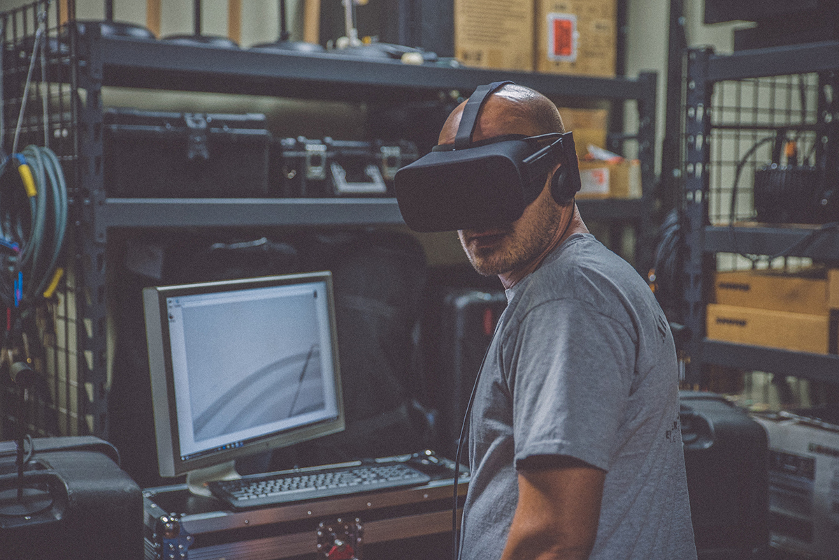 Man with VR headset on, sitting at a desk